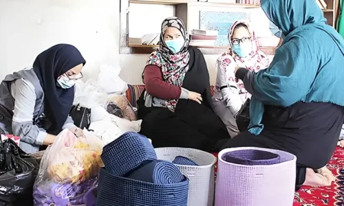 زنان در حال بررسی بسته‌های حمایتی و اقلام مورد نیاز در یک نشست اجتماعی